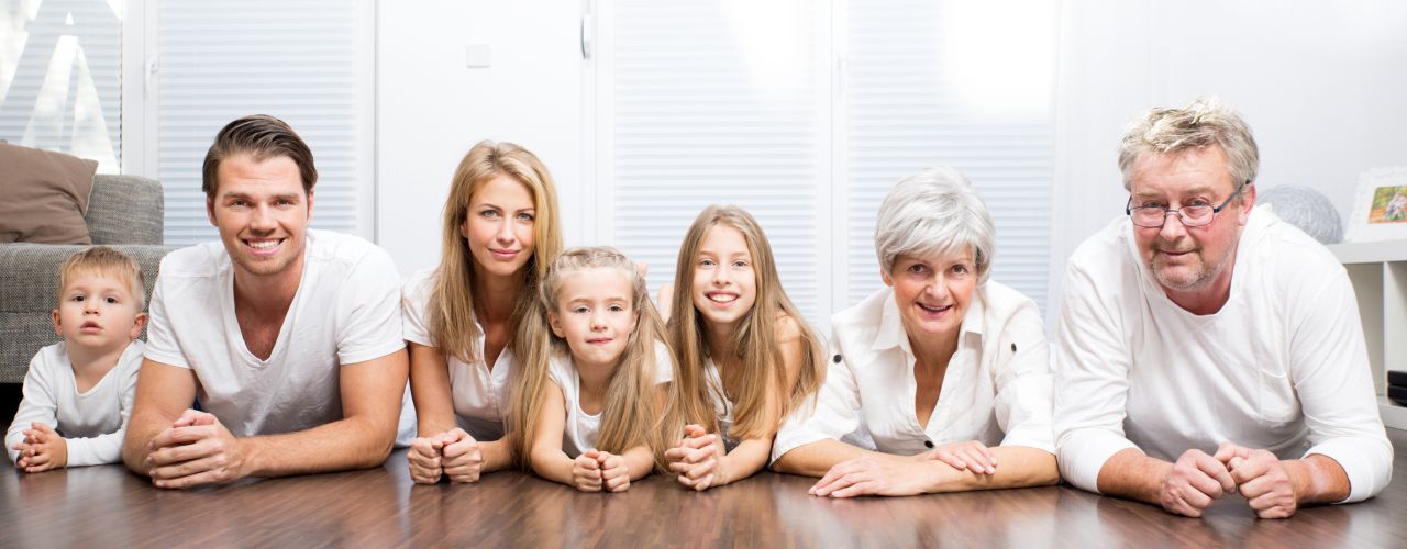 Eine fröhliche Familie mit Mutter, Vater, drei Kindern und den Großeltern.