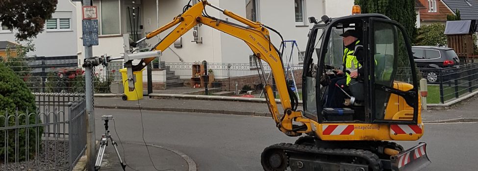 Mastenprüfer testen mit einem Bagger die Stabilität und Sicherheit der Laternenmasten im Ort.