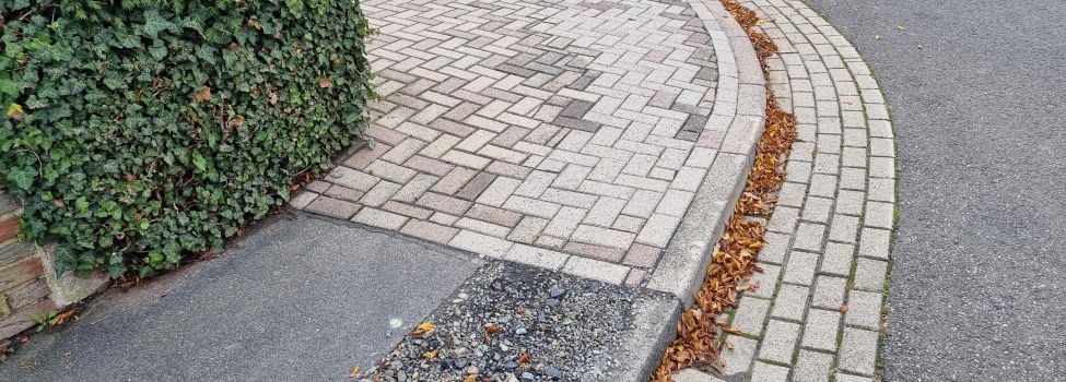 Hier die bereits ertüchtigte Pflasterarbeit im Rahmen der Abschlussarbeiten und nebenbei die noch ausstehende Asphaltarbeit an einem Gehweg im Ortsteil Sandershausen.