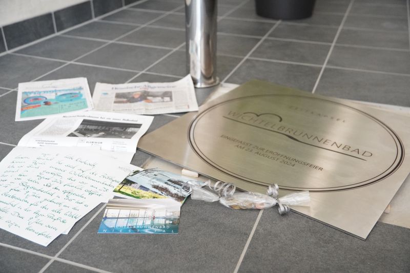 Die Zeitkapsel im Erdgeschoss birgt zahlreiche Zeitdokumente für nachfolgende Generationen, u.a. Zeitungen, einen Brief, Bilder des Wichtelbrunnenbades und einen Satz Münzen. @ Gemeinde Niestetal