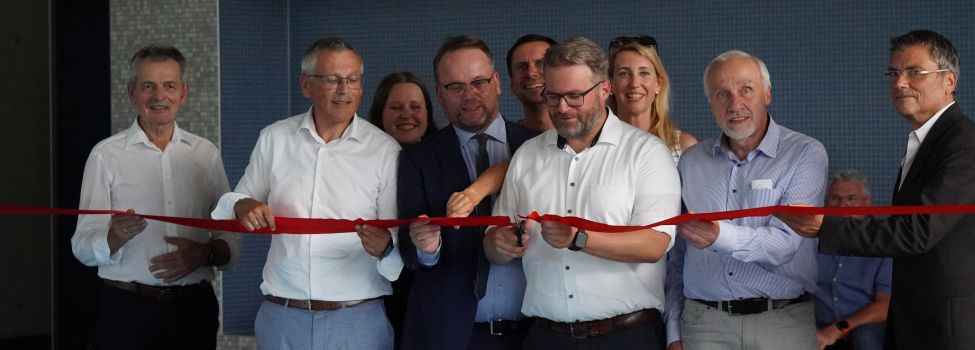 Seit dem 24. August ist unser neues Hallenbad, das Wichtelbrunnenbad in Niestetal eröffnet. An seiner Fassade hängt noch das große blaue Eröffnungsbanner. Das Bild zeigt Bürgermeister Marcel Brückmann beim durchtrennen des roten Bandes im beisein von den vier Fraktionsvorsitzenden Hörtsch, Schaumburg, Bartling und Weißenborn, zusammen mit Minister Gremmels, MdL Schölch, Landrat Siebert und Architekt Anderhalten. @ Gemeinde Niestetal