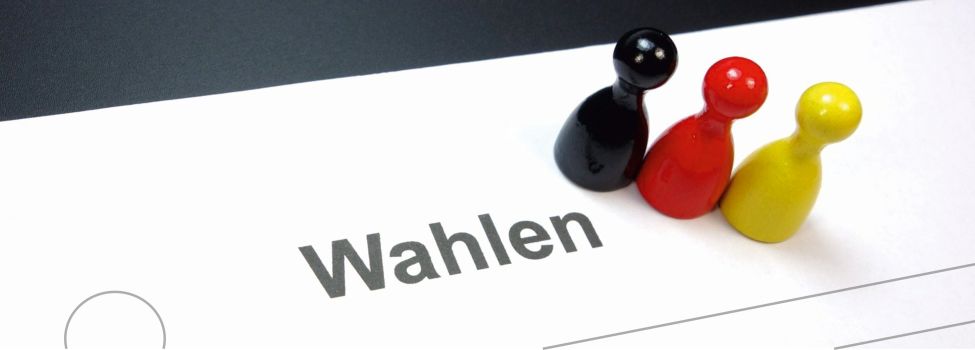 Auf dem Bild sieht man freie Wahlkästchen, einen Stift und die Deutschlandflagge