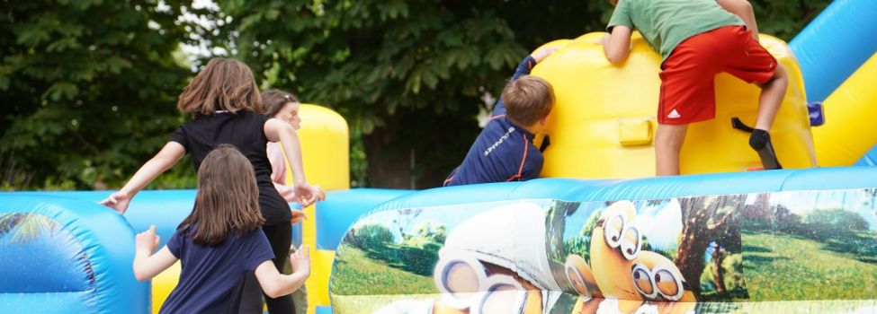 Kinder tollen auf der großen Hüpfburg des Abschlussfestes.