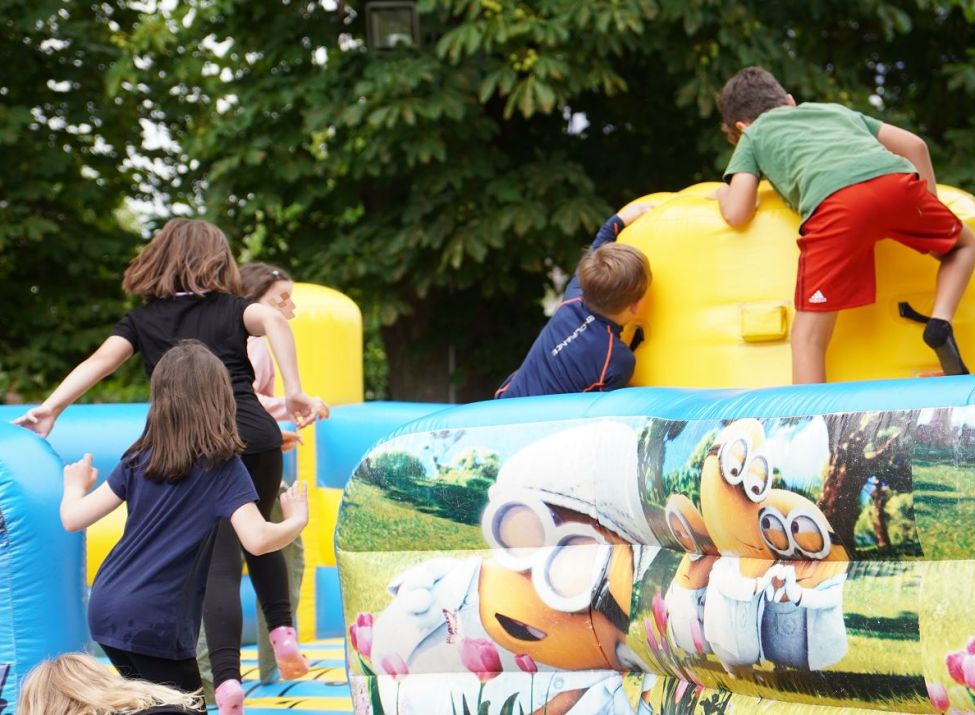 Kinder tollen auf der großen Hüpfburg des Abschlussfestes.
