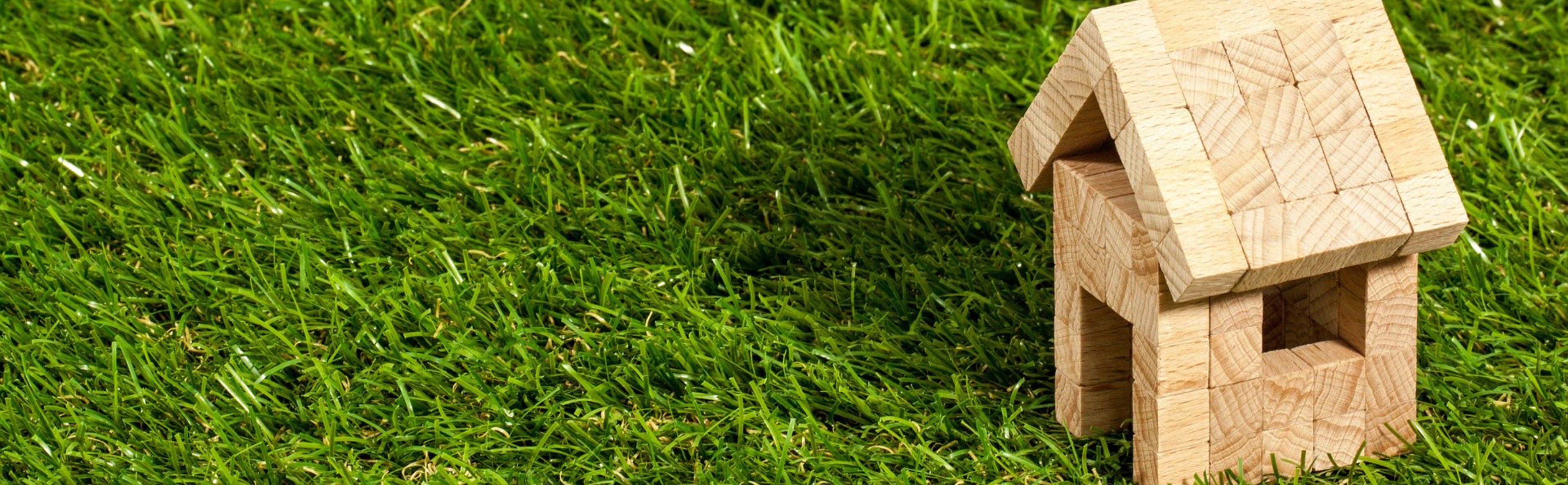 Beispielbild eines Eigenheims. Hier ein kleines Holz-Spielzeughaus auf einer Wiese. Beispielbild eines Eigenheims. Hier ein kleines Holz-Spielzeughaus auf einer Wiese.