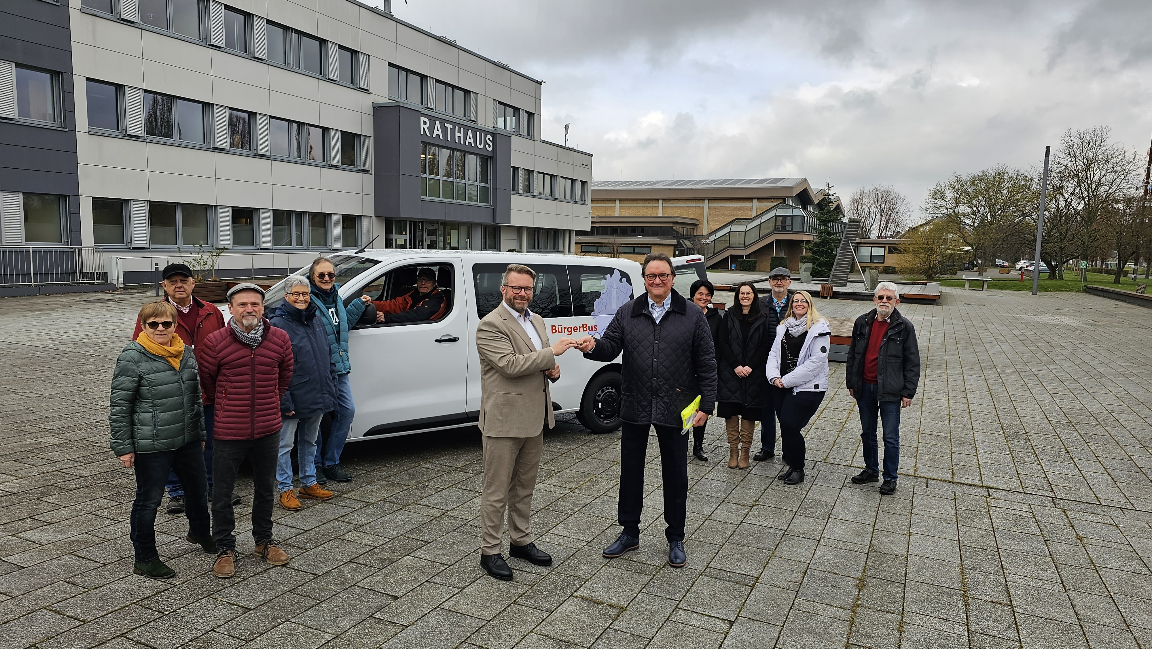 Bürgermeister Brückmann erhält, im Beisein aller ehrenamtlichen Fahrerinnen und Fahrer, den Schlüssel für den neuen E-Bus von Prof. Dr. Hein.